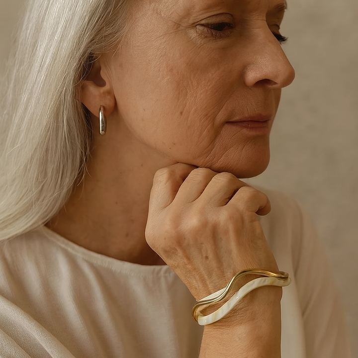 Elegante goudkleurige armband met witte opaal