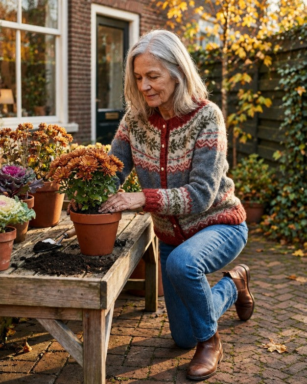 Vrouw in een gebreid vest aan het werk in haar tuin in de herfst