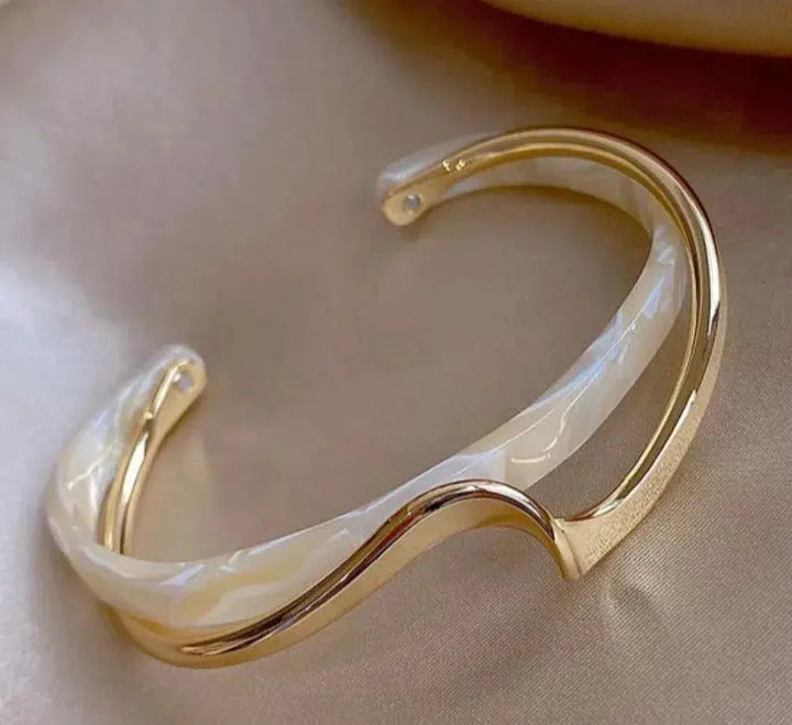 Elegante goudkleurige armband met witte opaal
